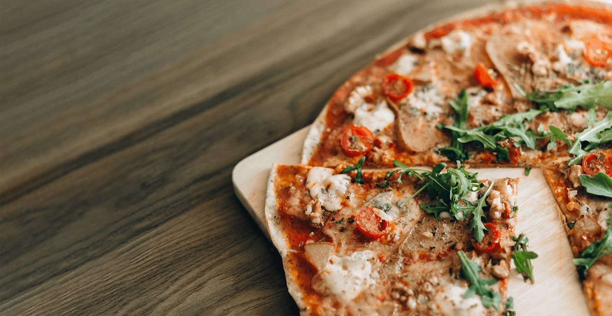 Hero image of an Italian Pizza with arugula toppings